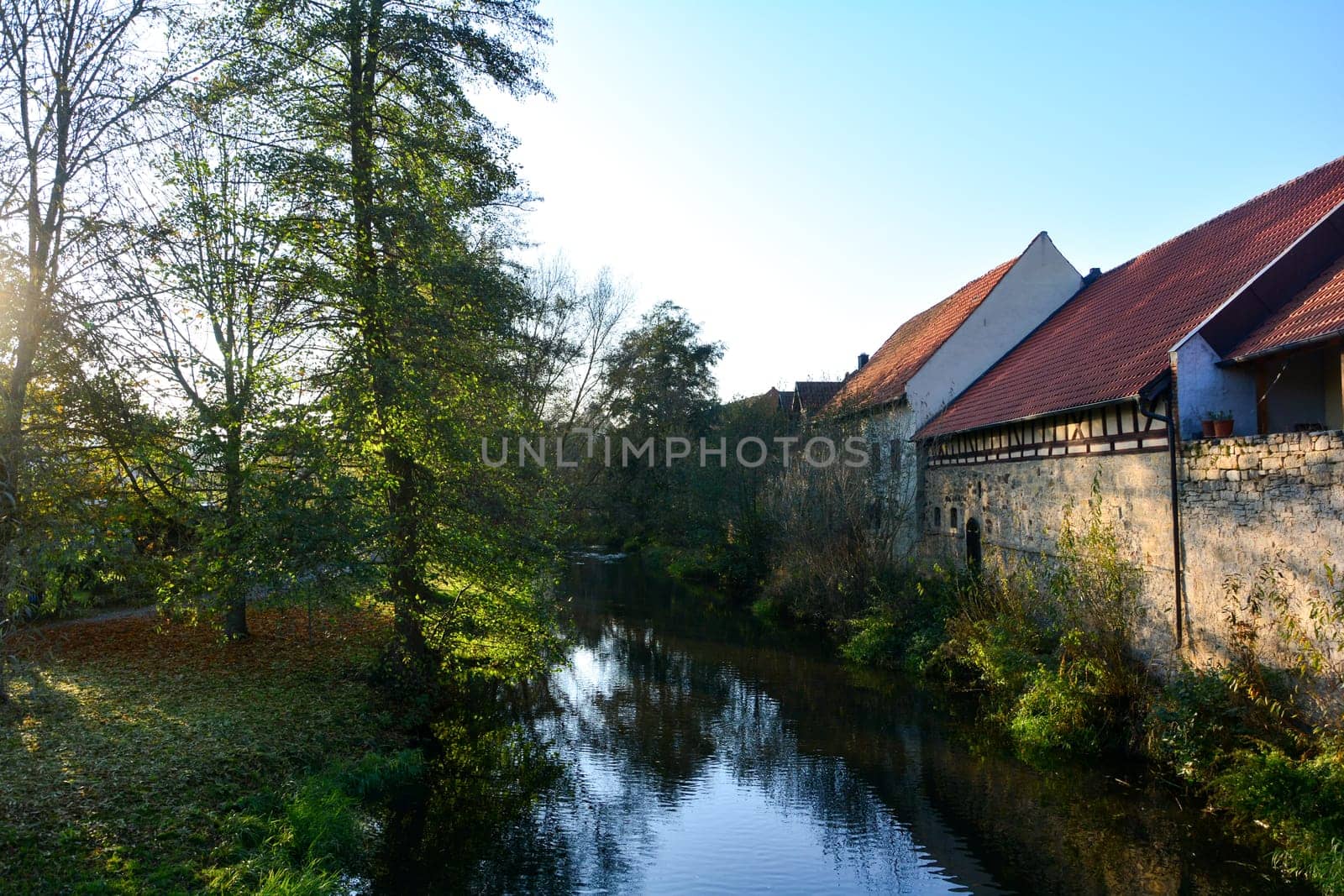 Small stream with nature and old houses in the evening light, in Ostheim , Rhoen, Bavaria, Germany