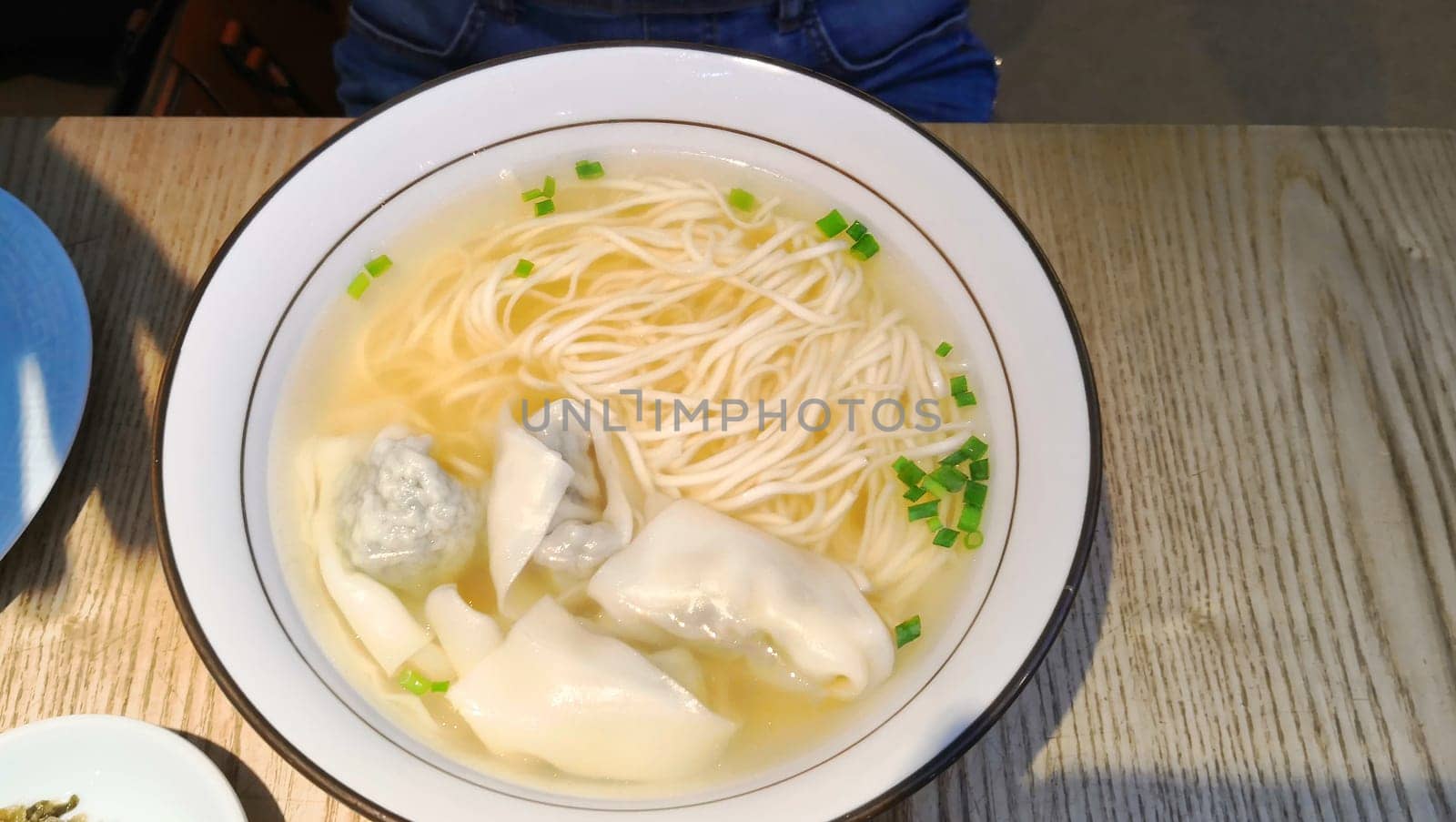 Wontons in a broth with noodles. Chinese cuisine.