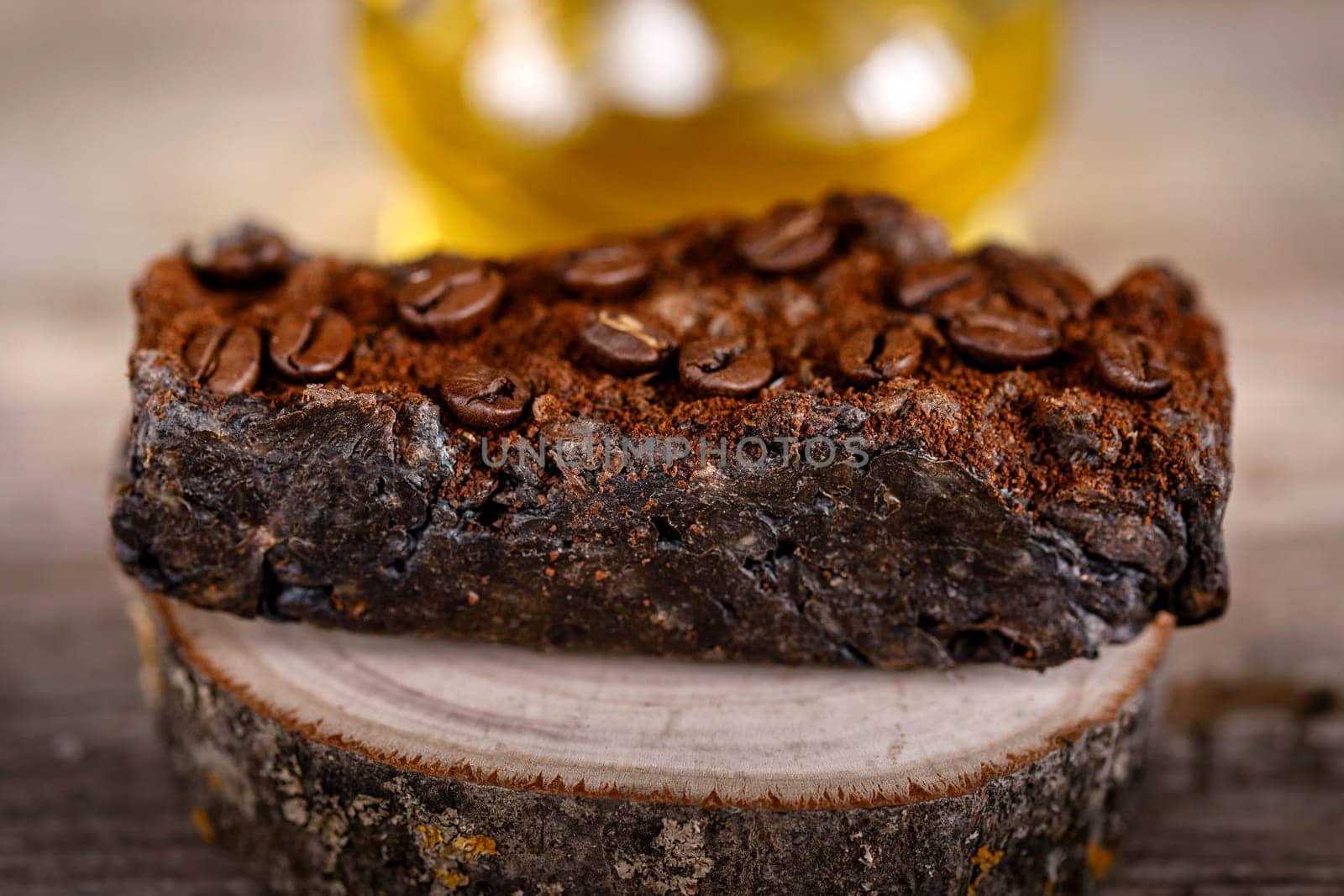 Handmade scrub soap on a wooden stand with ground coffee for relaxation and water treatments