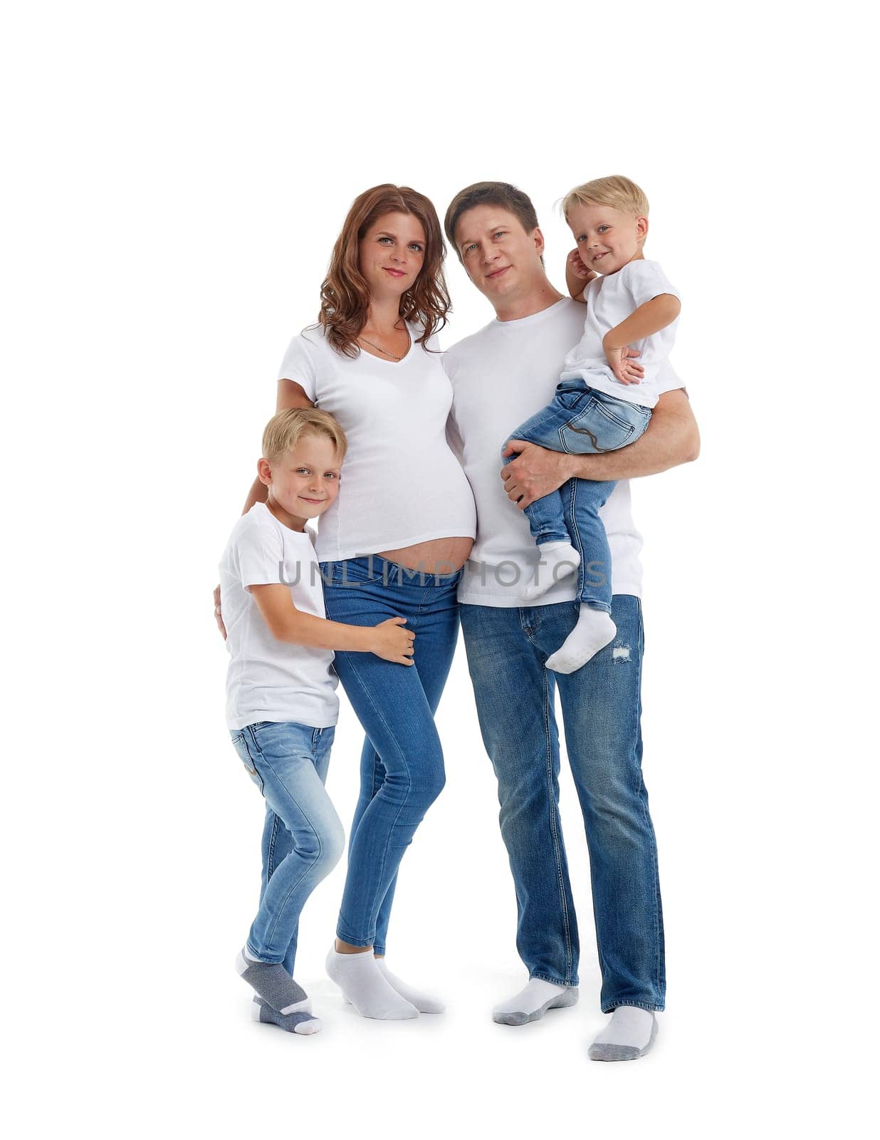 Happy parents: pregnant mother and father with lovely two sons are stand  and smiling, isolated on a white background. Happy friendly family. Concept of people and family