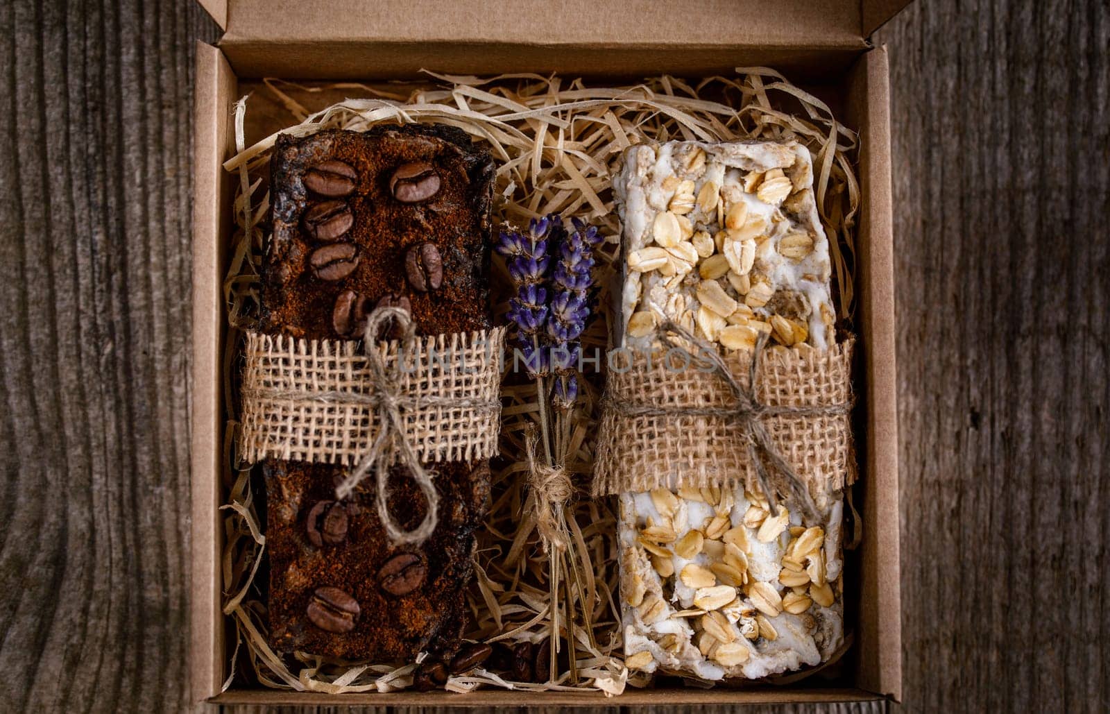 Handmade scrub soap in a cardboard box, decorated with straws, burlap and dry lavender