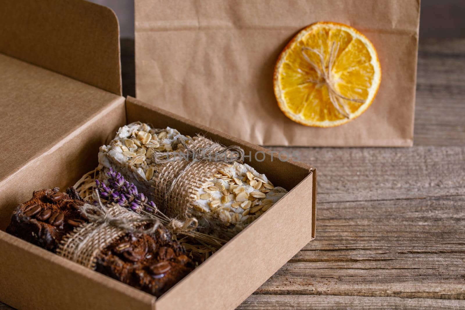 Handmade soap with natural fillers, in a gift cardboard box, next to an eco package, with jute decoration