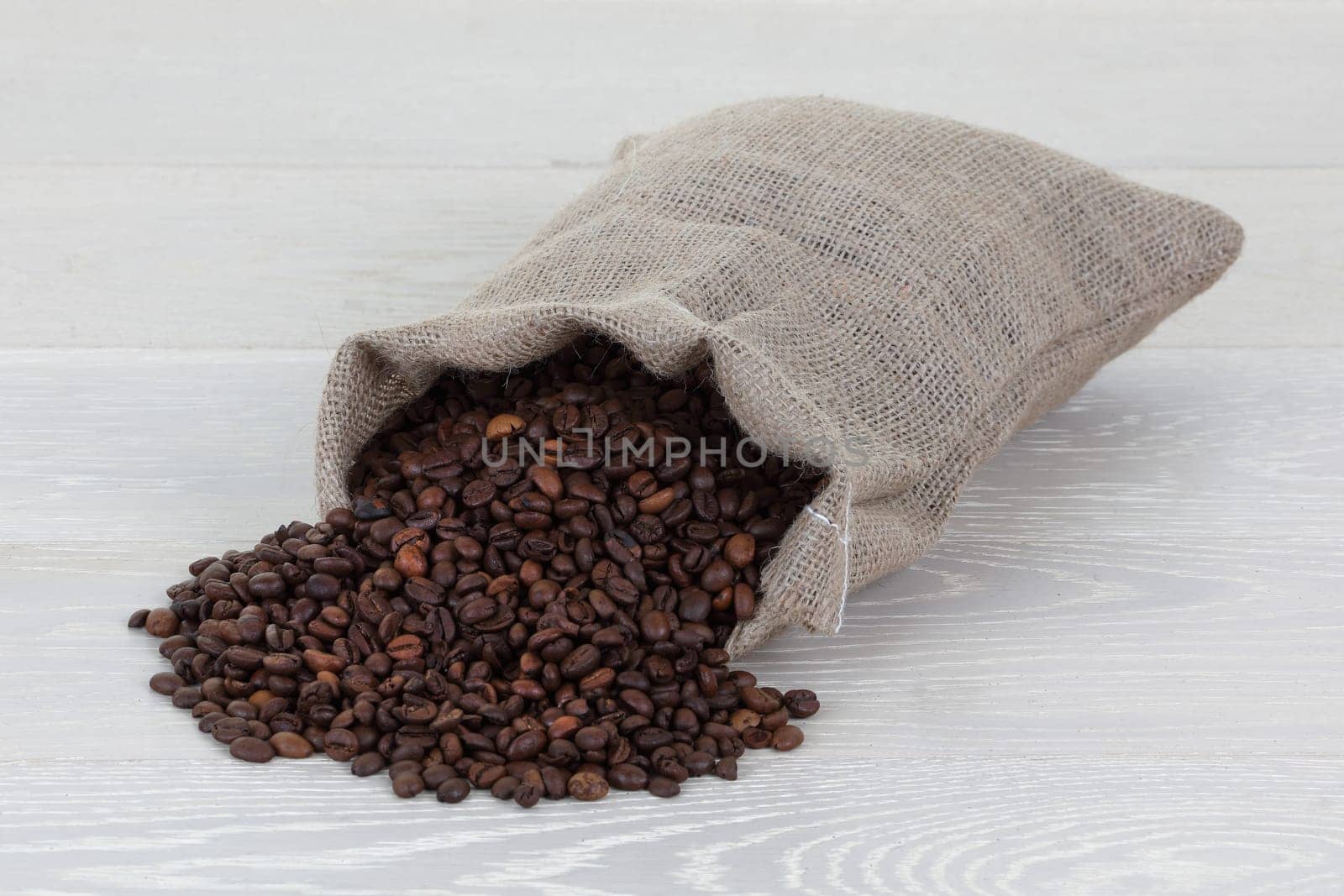 Coffee beans and hessian bag on wood surface