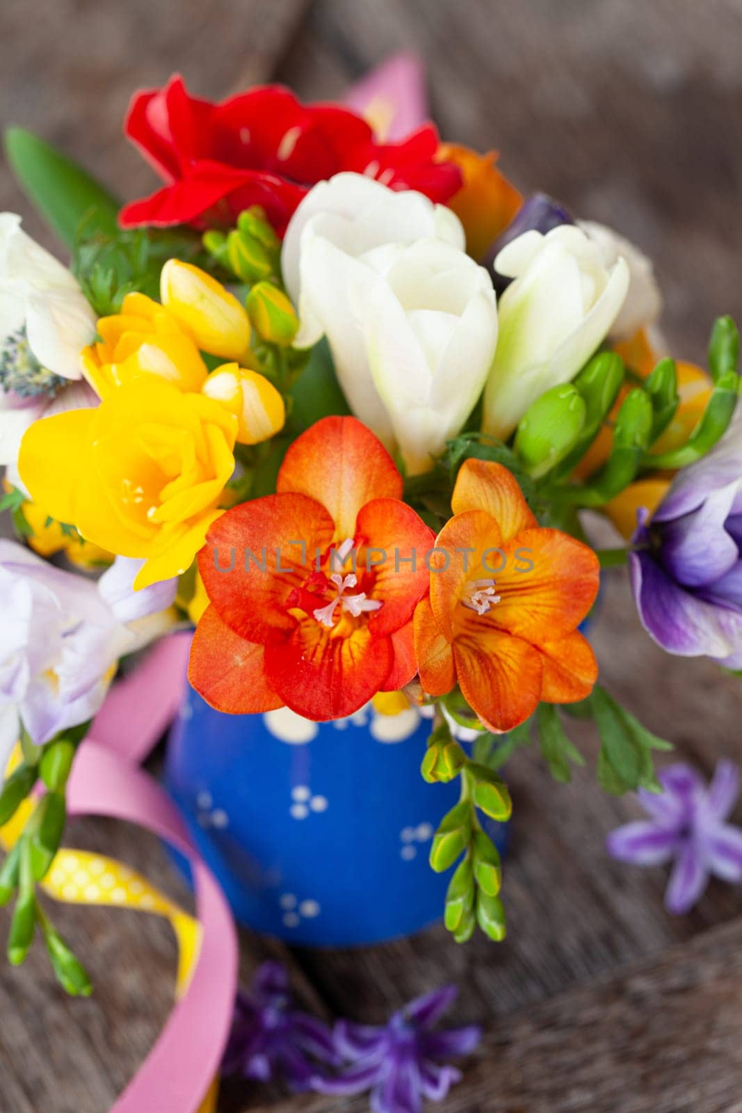 Bunch of colorful spring flowers in a little vase