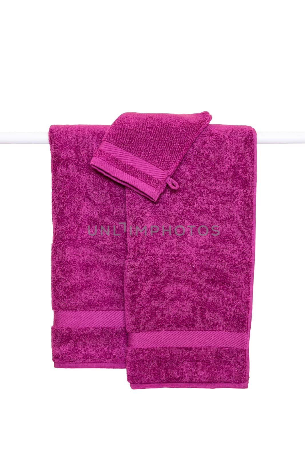 Hanging towels isolated. Closeup of violet soft terry bath towels hang on a clothes rail isolated on a white background.