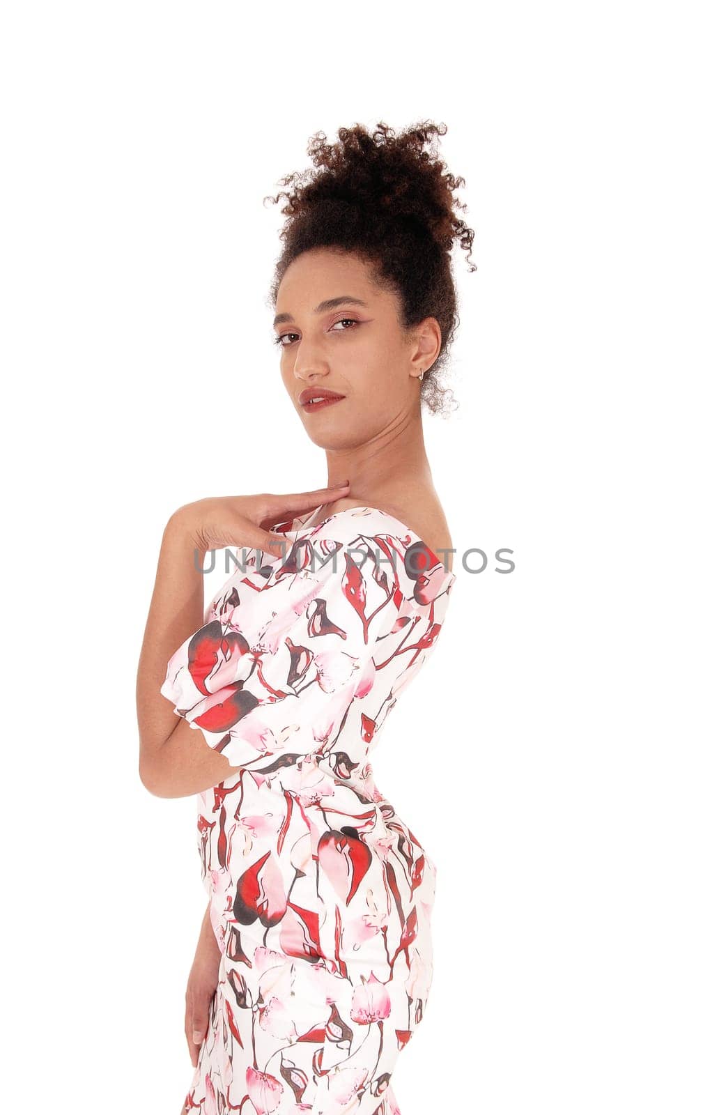 A close up image of a multi-racial woman standing in profile in a summer.dress holding one hand on her chest with a slim figure and curly black.hair, isolated for white background.