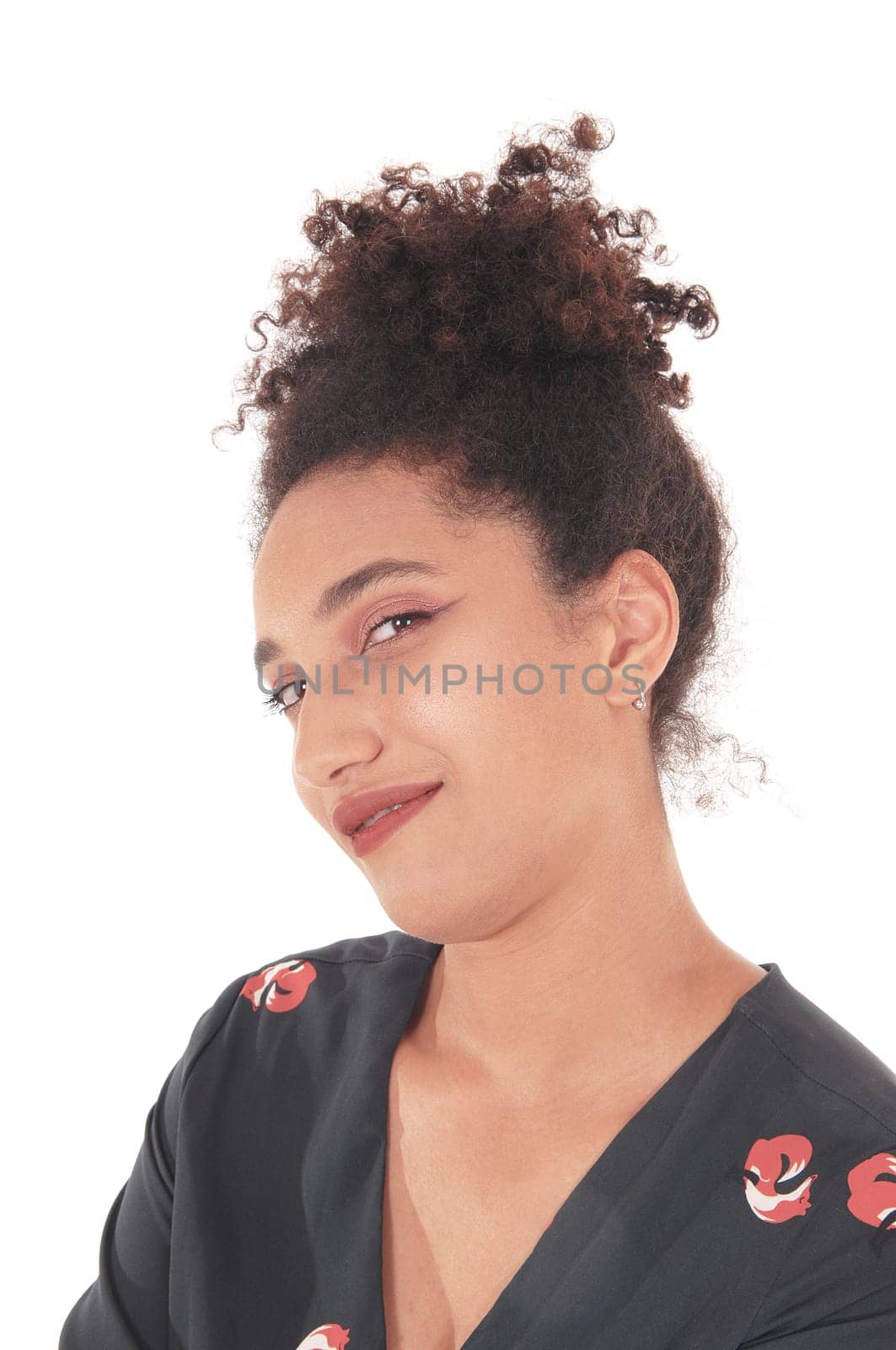 Close up image of a beautiful multi-racial woman in a black dress with.some print on looking into the camera with her black hair in a bun.of her head, isolated for white background.