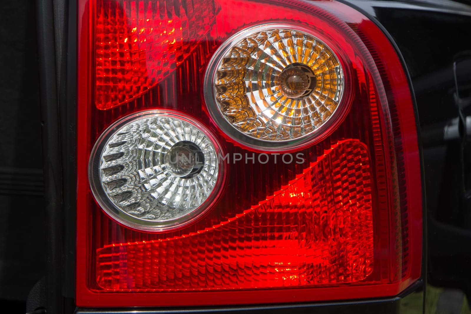 Detail on the rear light of a black modern car