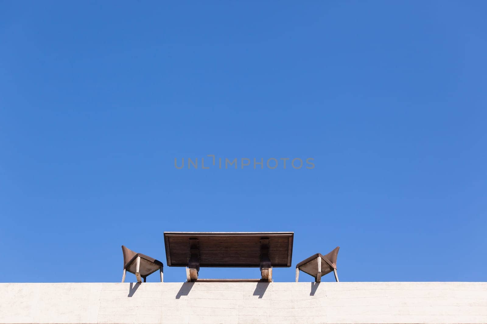 Chairs Table on edge of building outdoor in blue sky in abstract danger concept of trust integrity fraud .