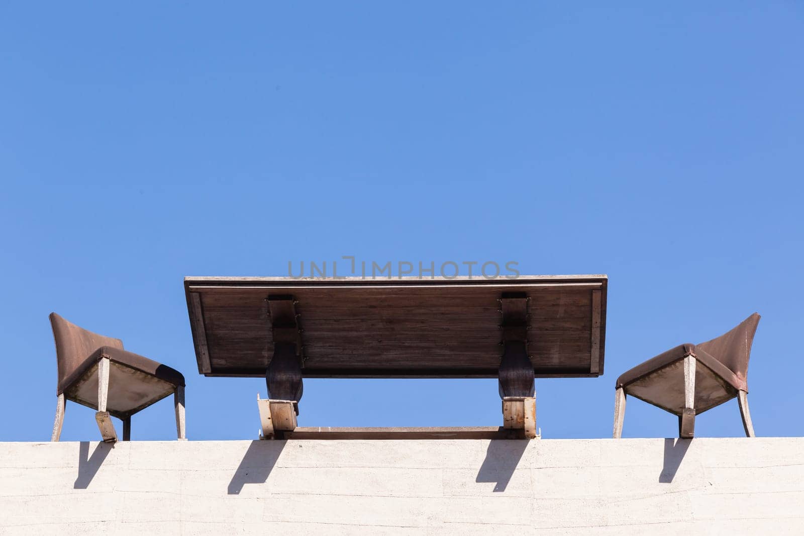 Chairs Table on edge of building outdoor in blue sky in abstract danger concept of trust integrity fraud .