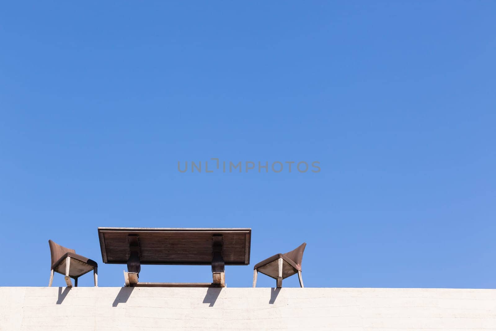 Chairs Table on edge of building outdoor in blue sky in abstract danger concept of trust integrity fraud .