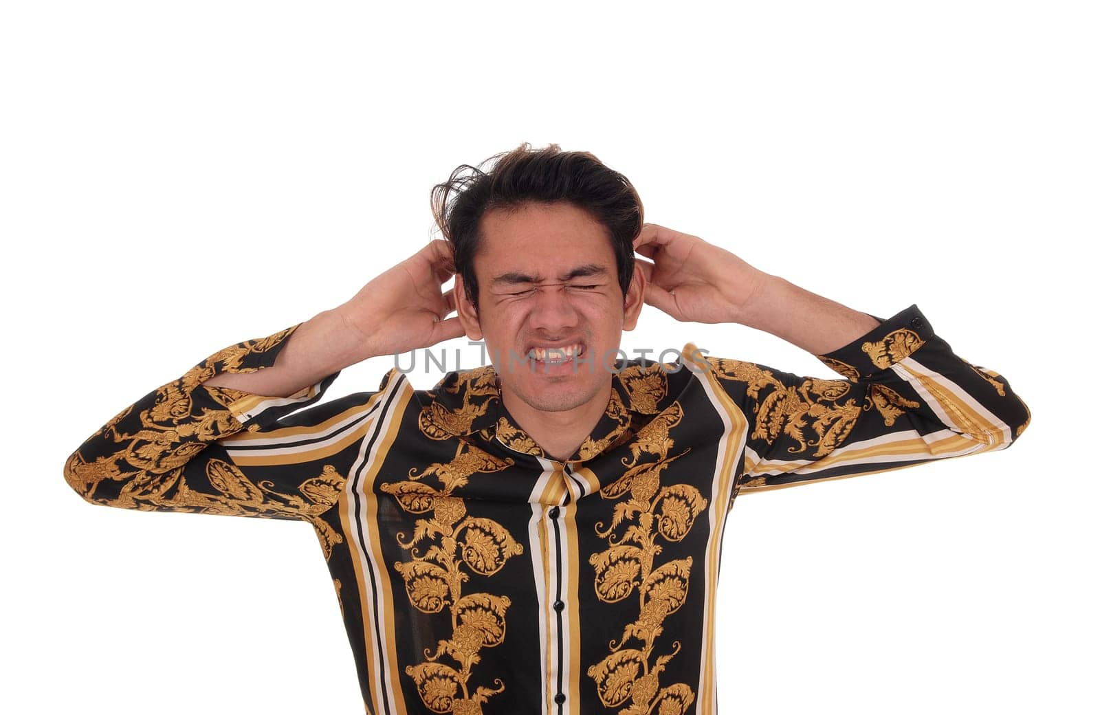 A young sad looking man standing from the front with his hands on his.head, is in distress for the bad headache, isolated for white background.