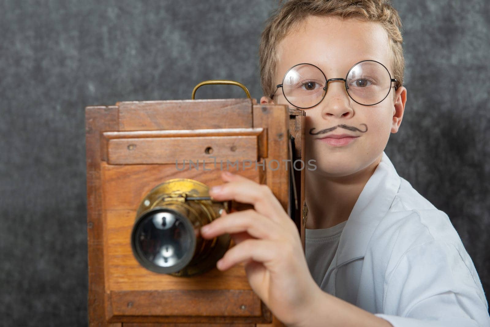 cheerful boy retro photographer with a vintage wooden camera