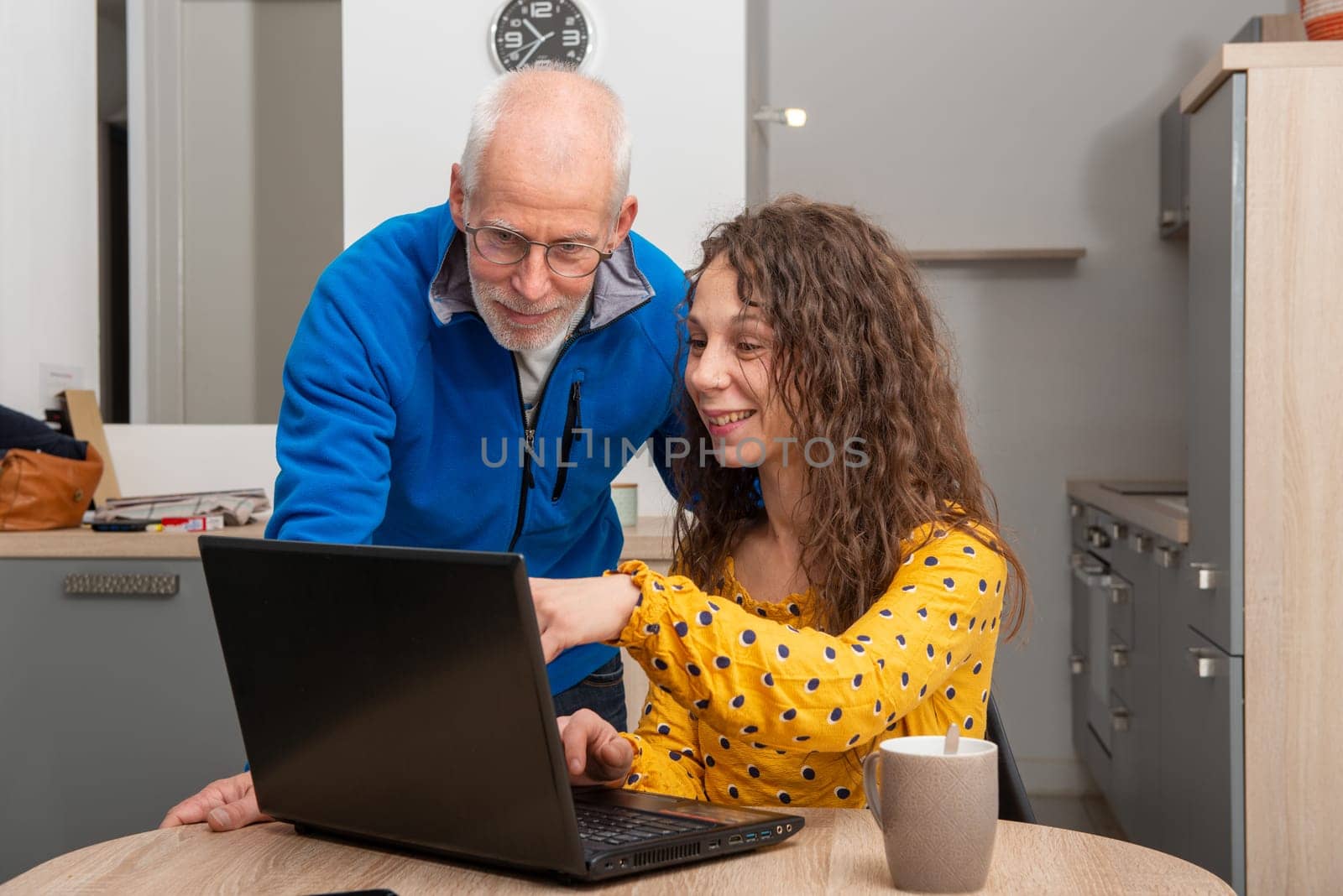 Young woman helps senior on a laptop computer
