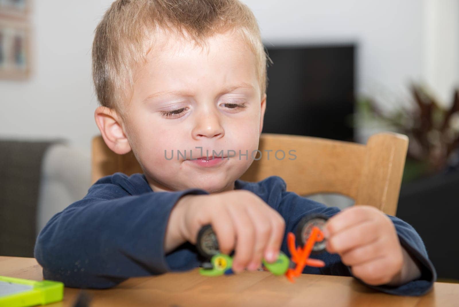 a little boy two years playing with her toys