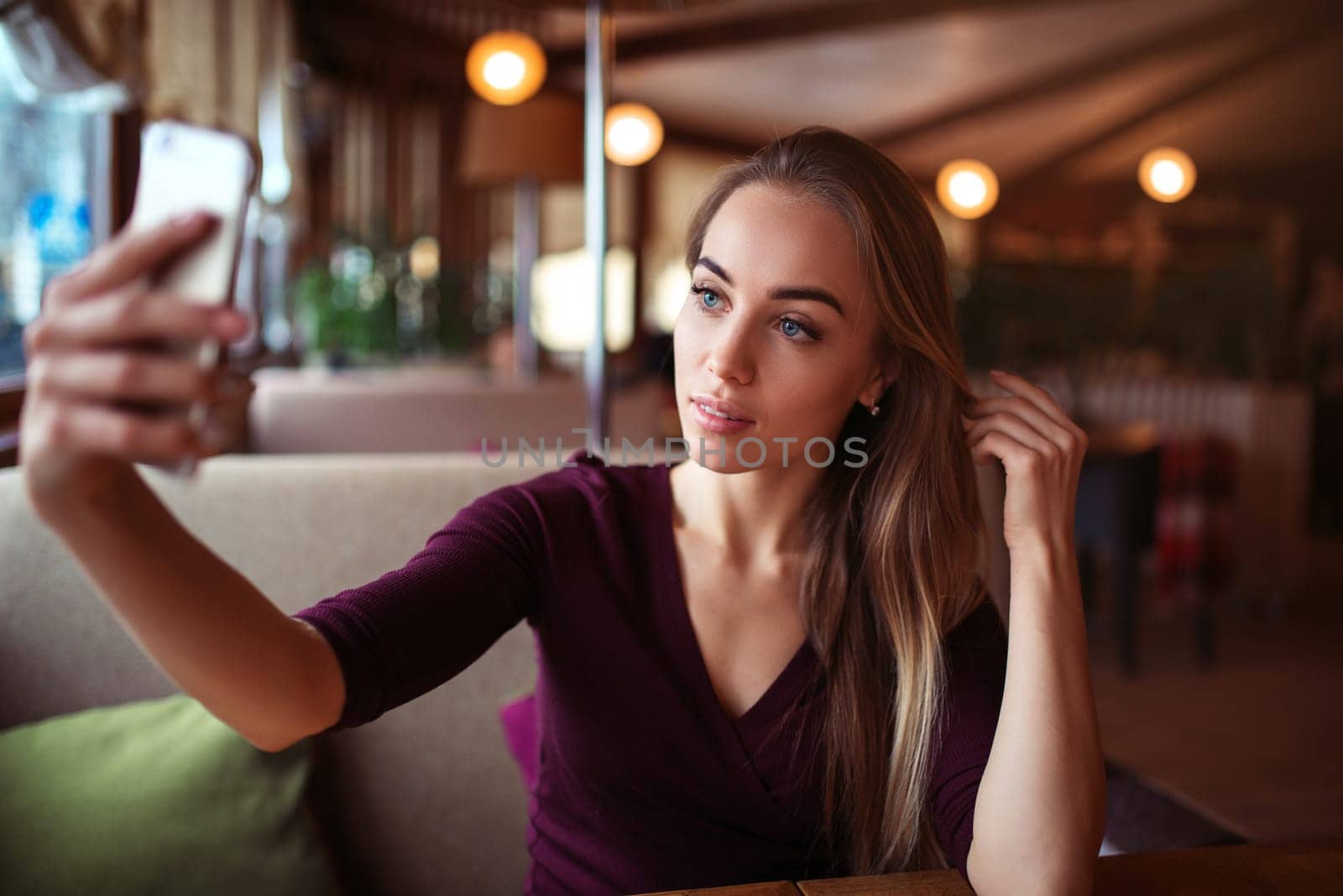 Young beautiful woman make selfie in restaurant.