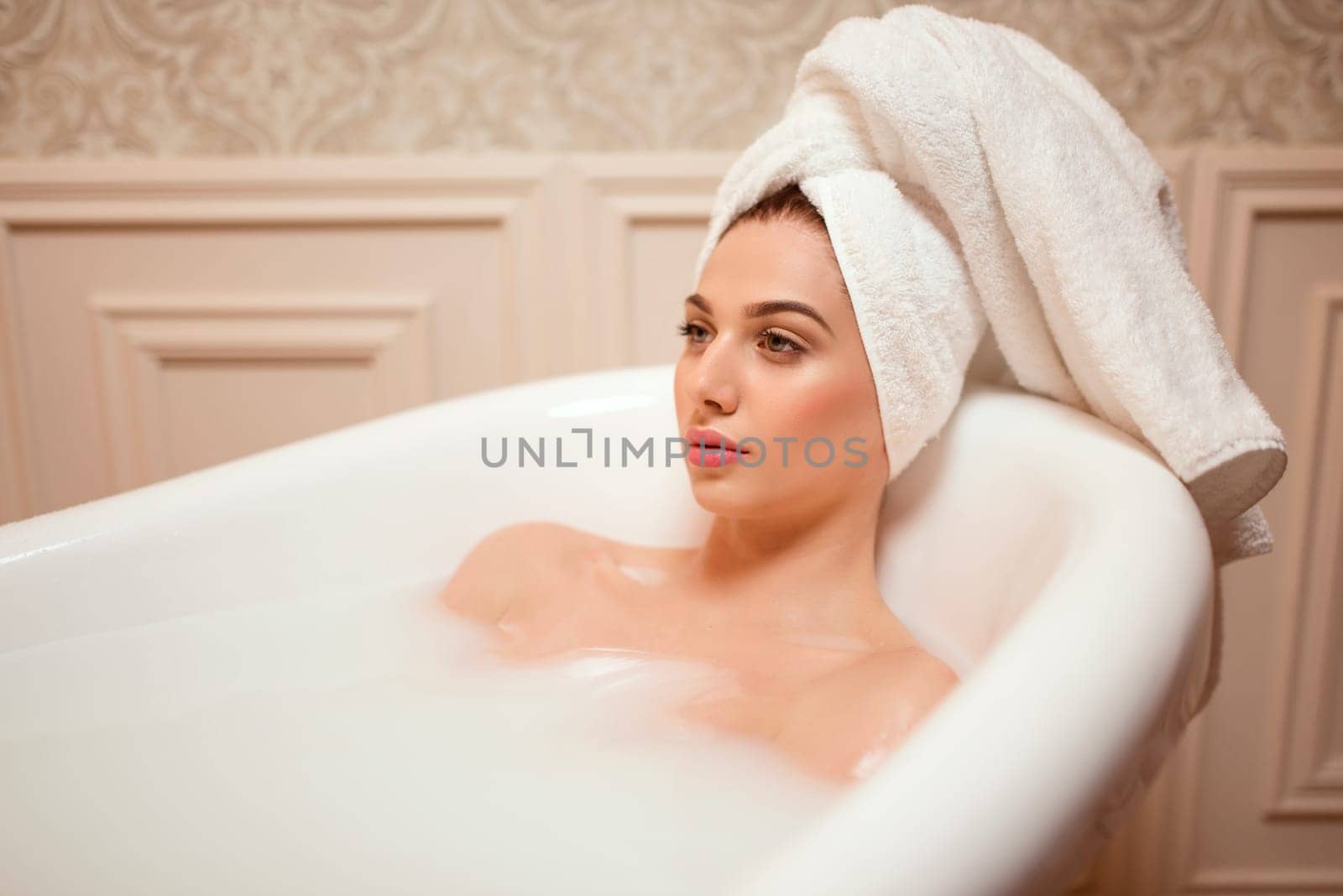 Beautiful woman in the bathroom. Female relaxation in bathtub.