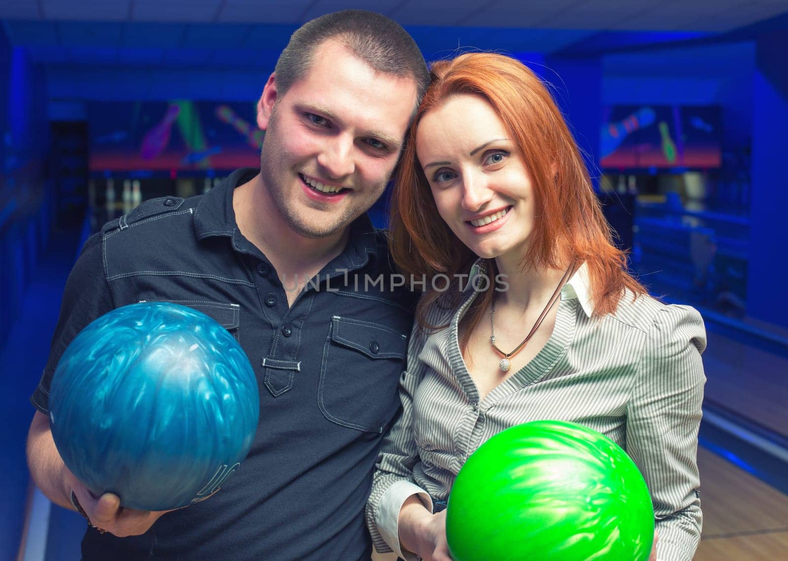 Happy couple in a bowling alley having fun