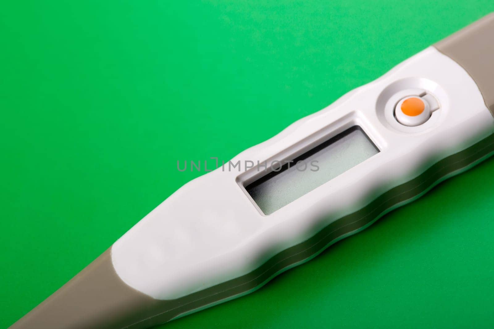 Closeup of digital thermometer on green