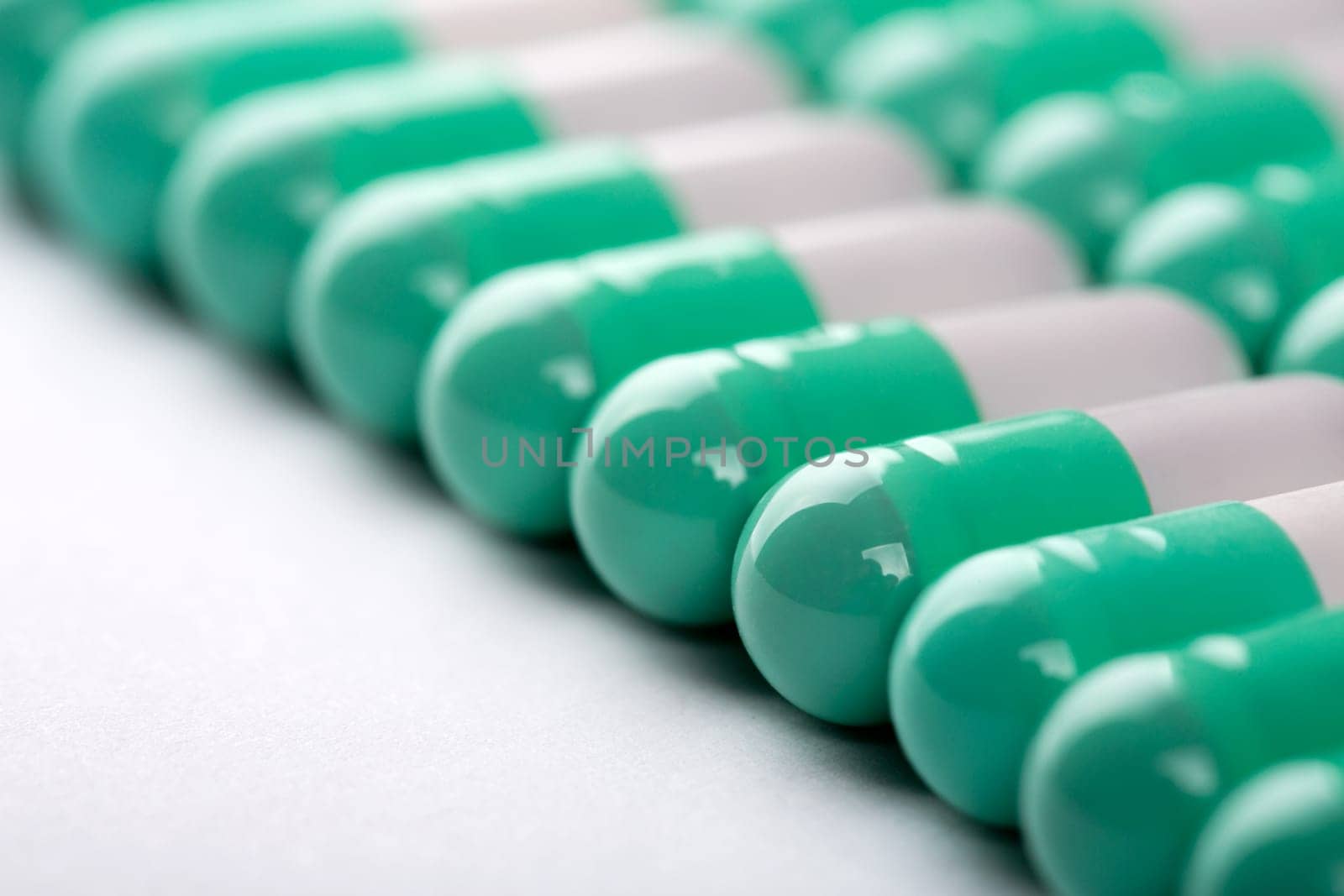 Closeup of green-white pills in a row