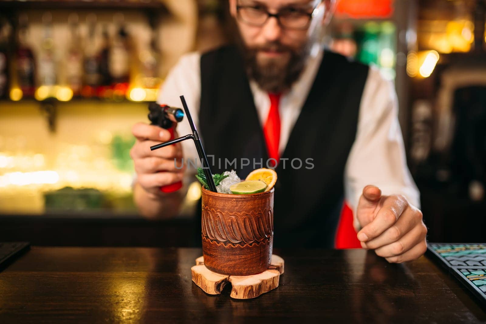 Bartender making alcohol beverage with gas burner. Professional bartending