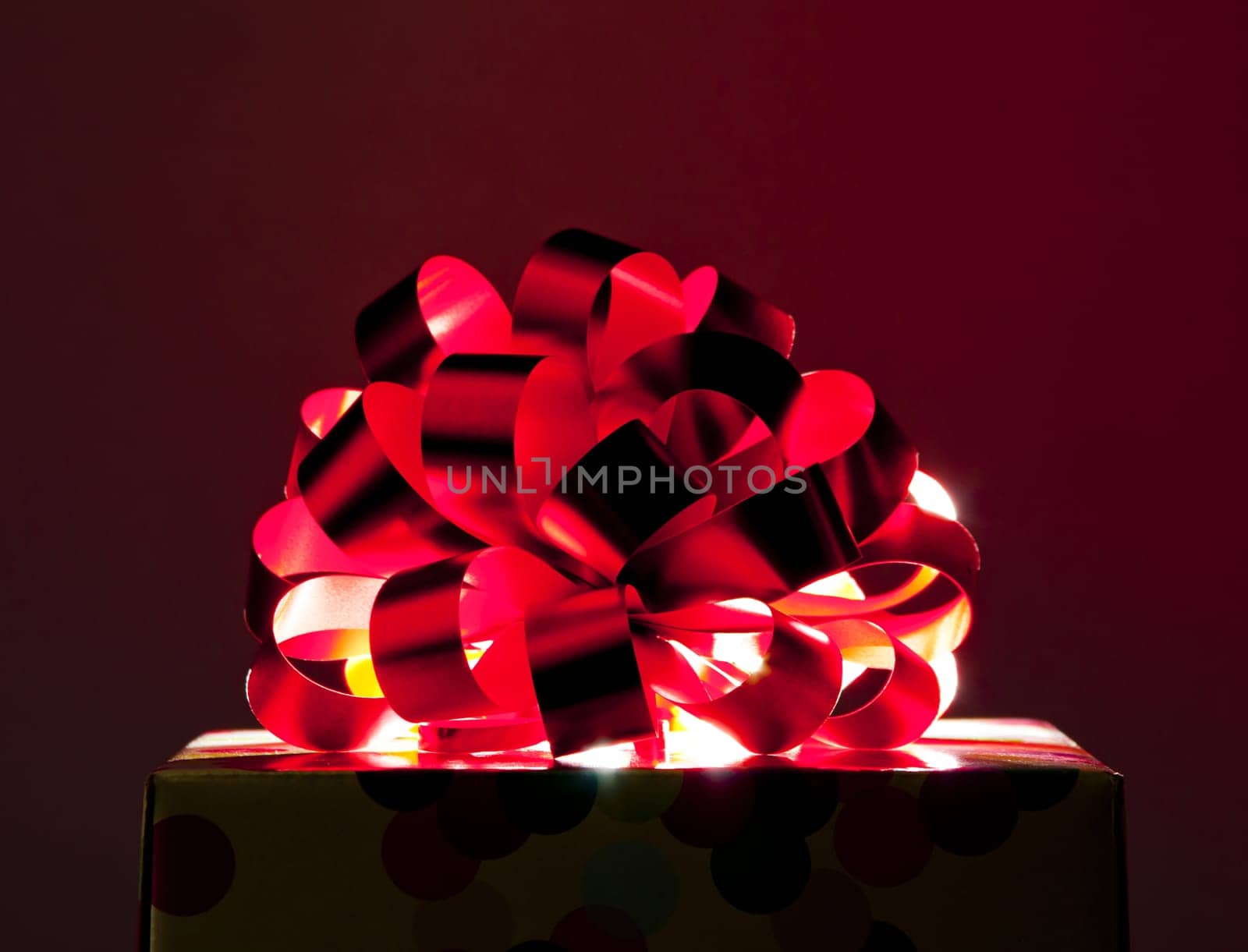 Gift with big red bow and ribbon. Backlight