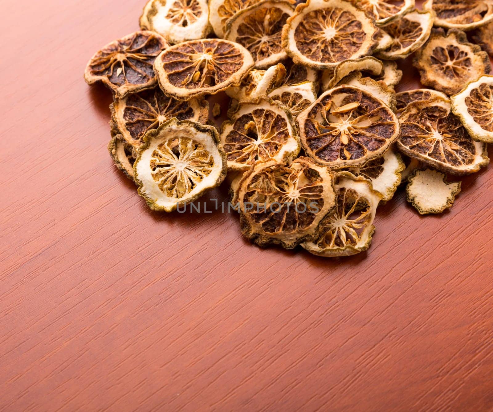 Pile of dried lime slices on wooden table