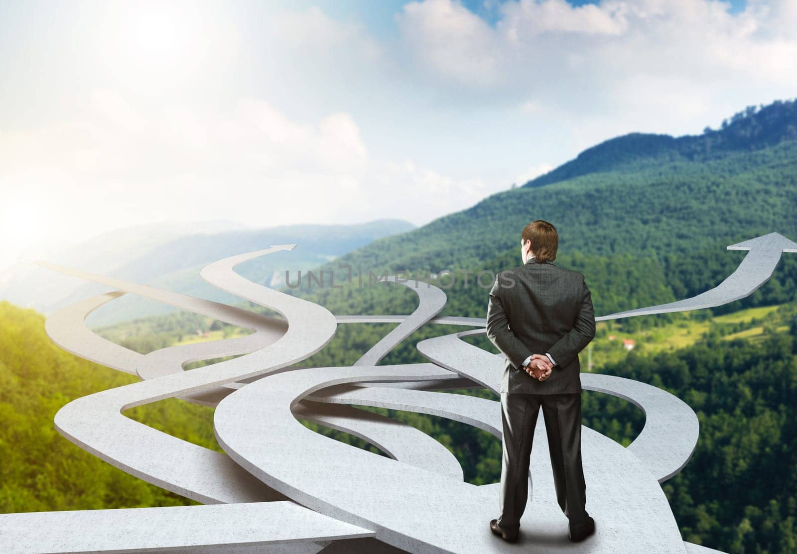 Businessman stands choosing his way on nature background