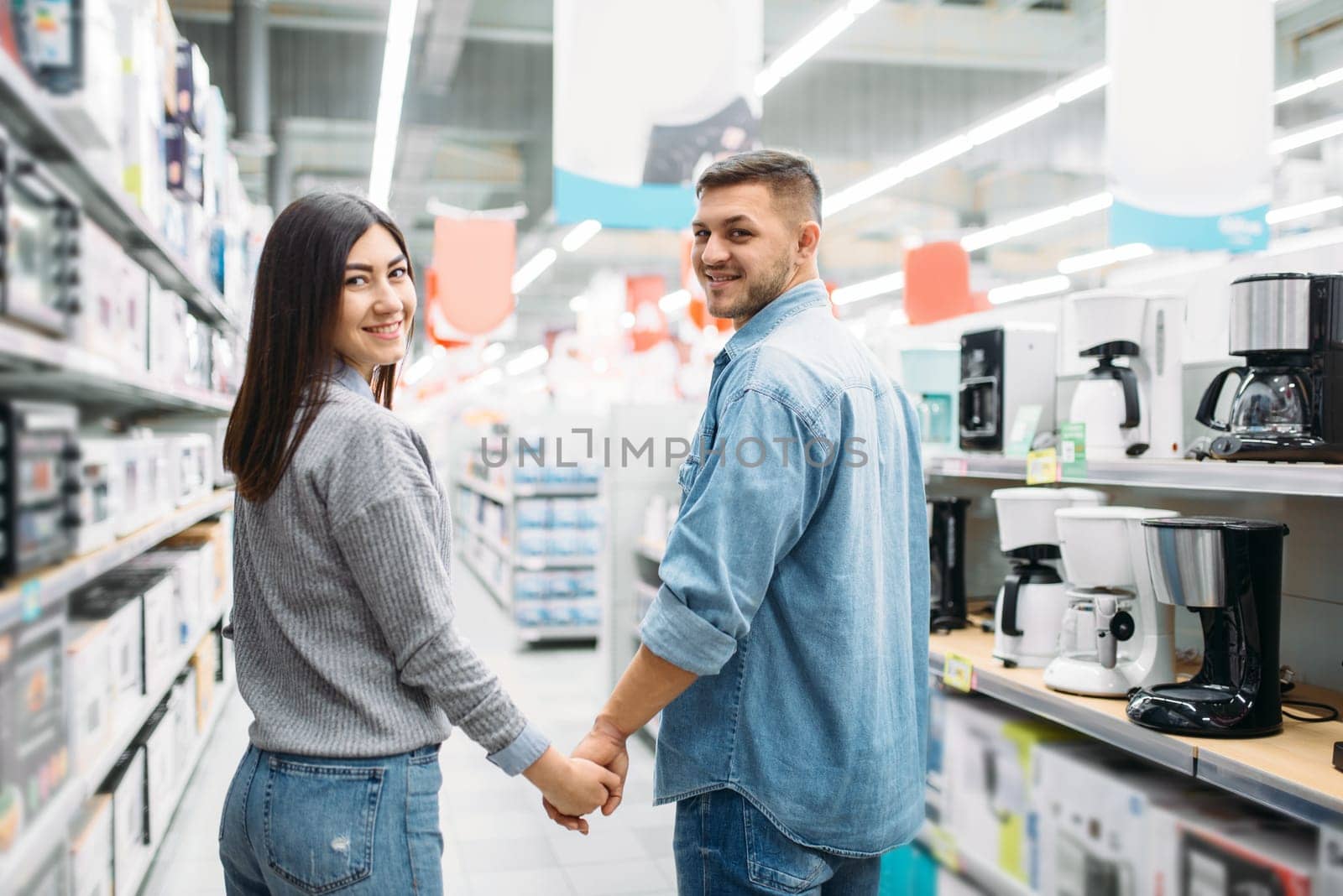 Couple in department of household appliances, market. Customers in shop, family choosing consumer goods