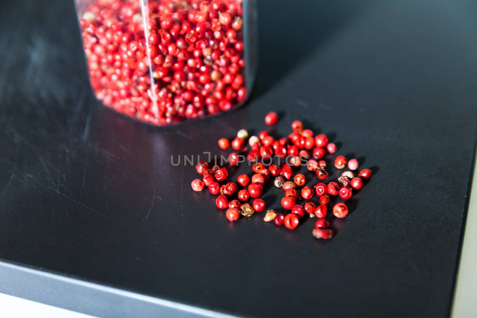 Dried red berries in glass jar and on the table