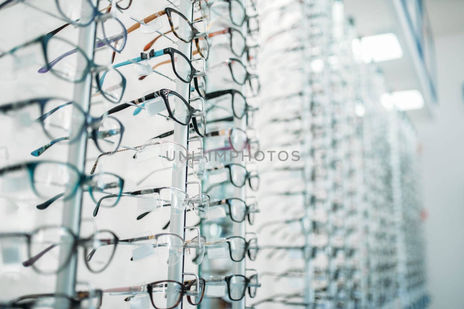 Eyeglasses and sunglasses showcase in optic shop, nobody. Eye vision protection, optical store accessory on shelves