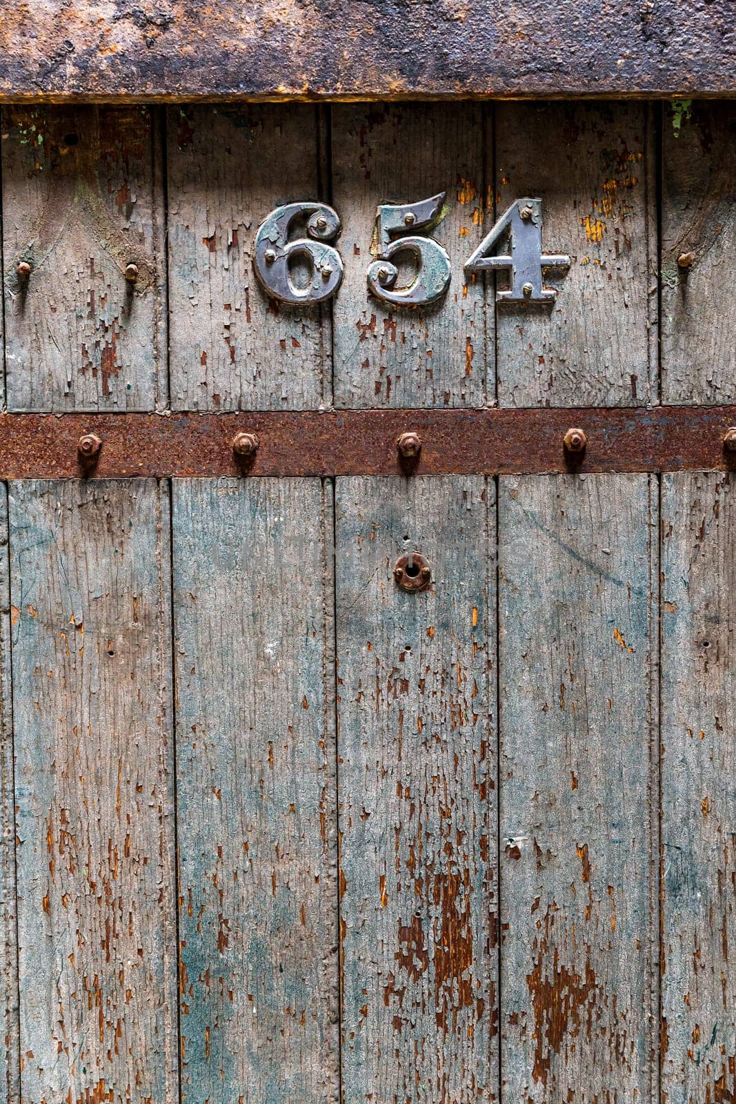 Wooden old prison door closeup. Jail door with number 654