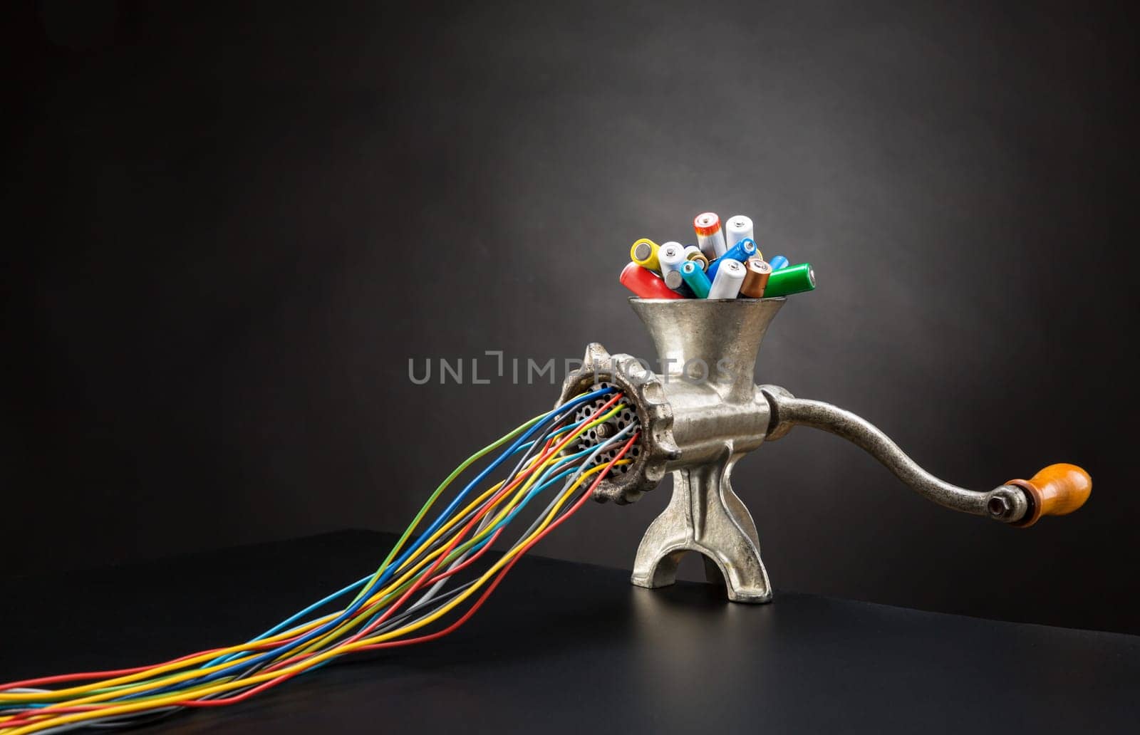 Mincing machine is grinding up colorful batteries to cables