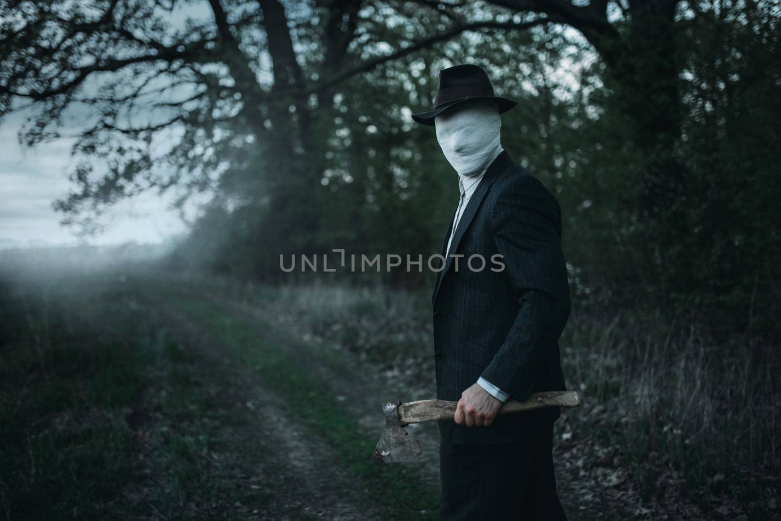 Serial maniac with axe in the forest, face wrapped in bandages, bloody killer concept, crazy murderer, crime and violence horror