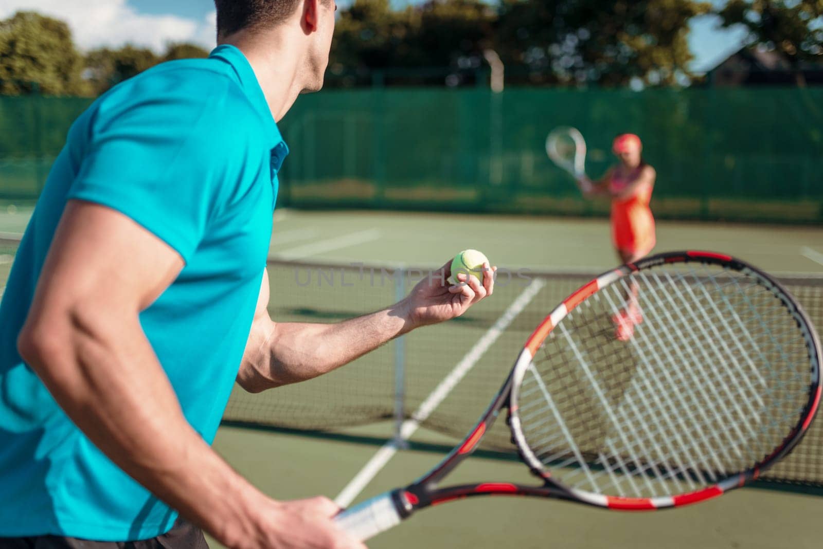 Male and female players with rackets on outdoor tennis court. Summer season active sport game