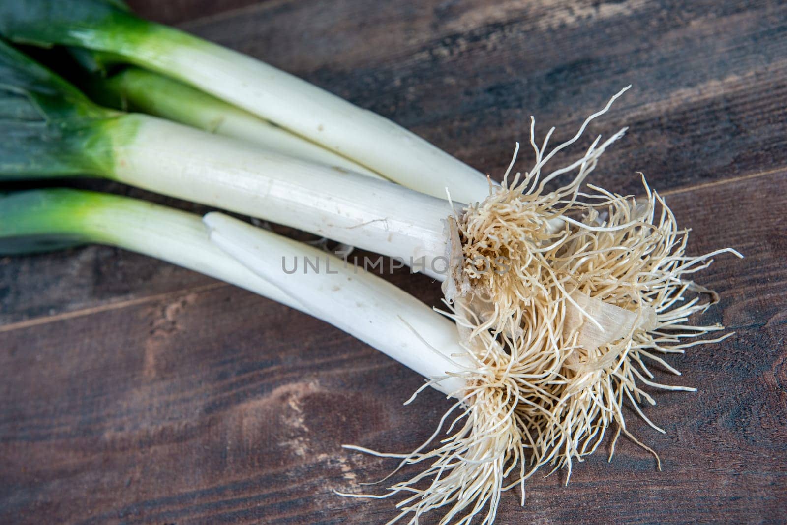 Fresh raw leeks on the wooden table
