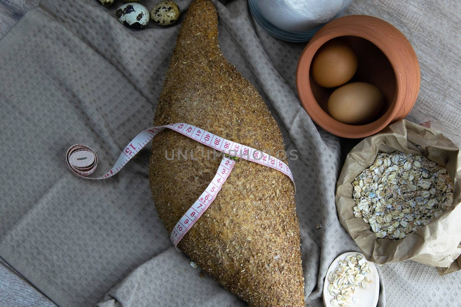 Crisp oatmeal bread wrapped with a measuring tape with i'm yits and oatmeal in the background. Top views with clear space
