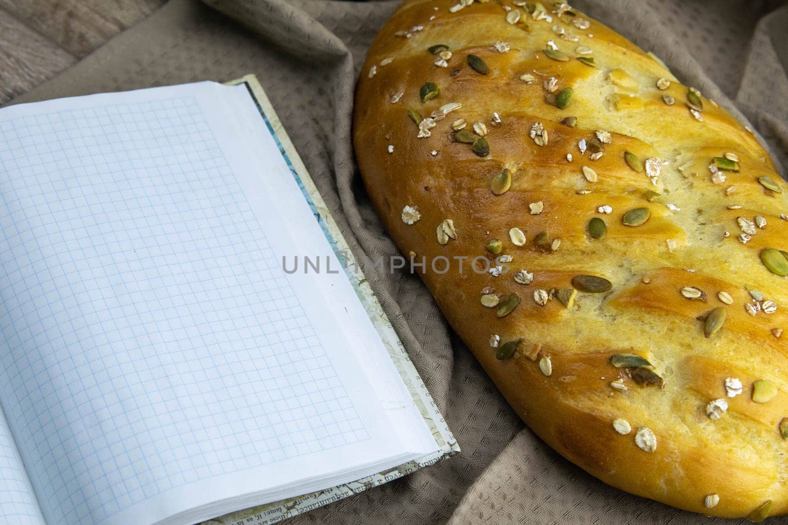 Concept shot of spice bread sticks with a wooden spoon on the wood table, oatmeal and a skein of bag thread, egg, flour, seeds and nuts. Front views