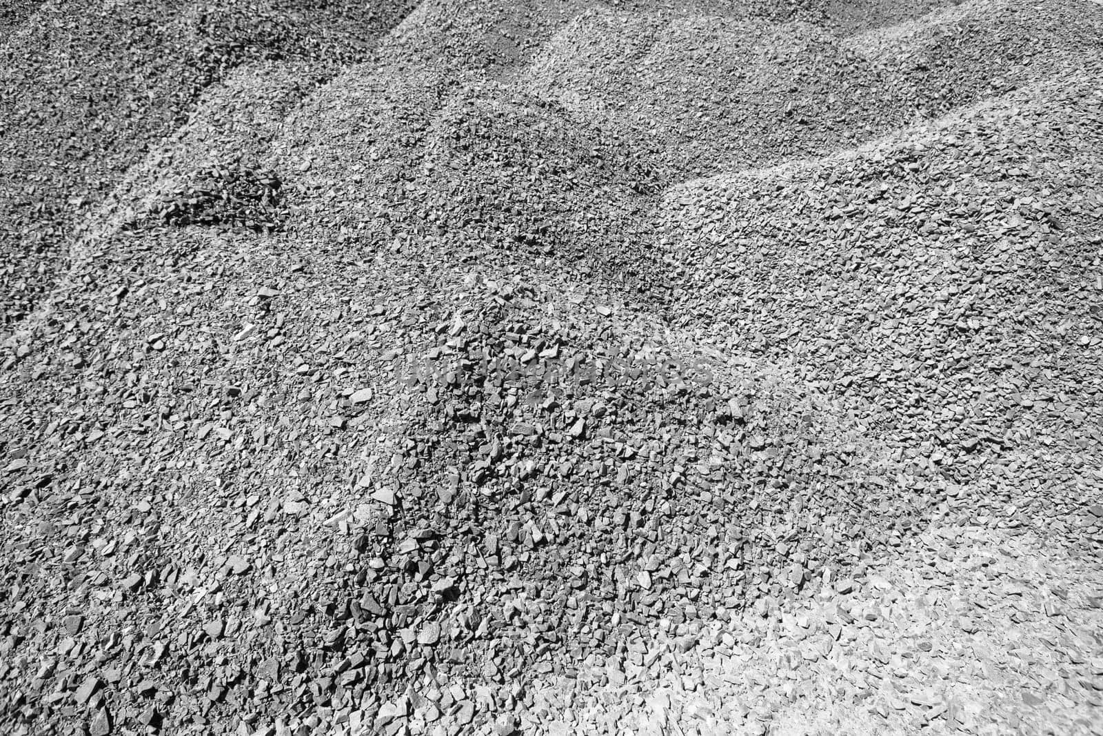 Raw stone piles in black white background detail from quarry for concrete mixing on construction