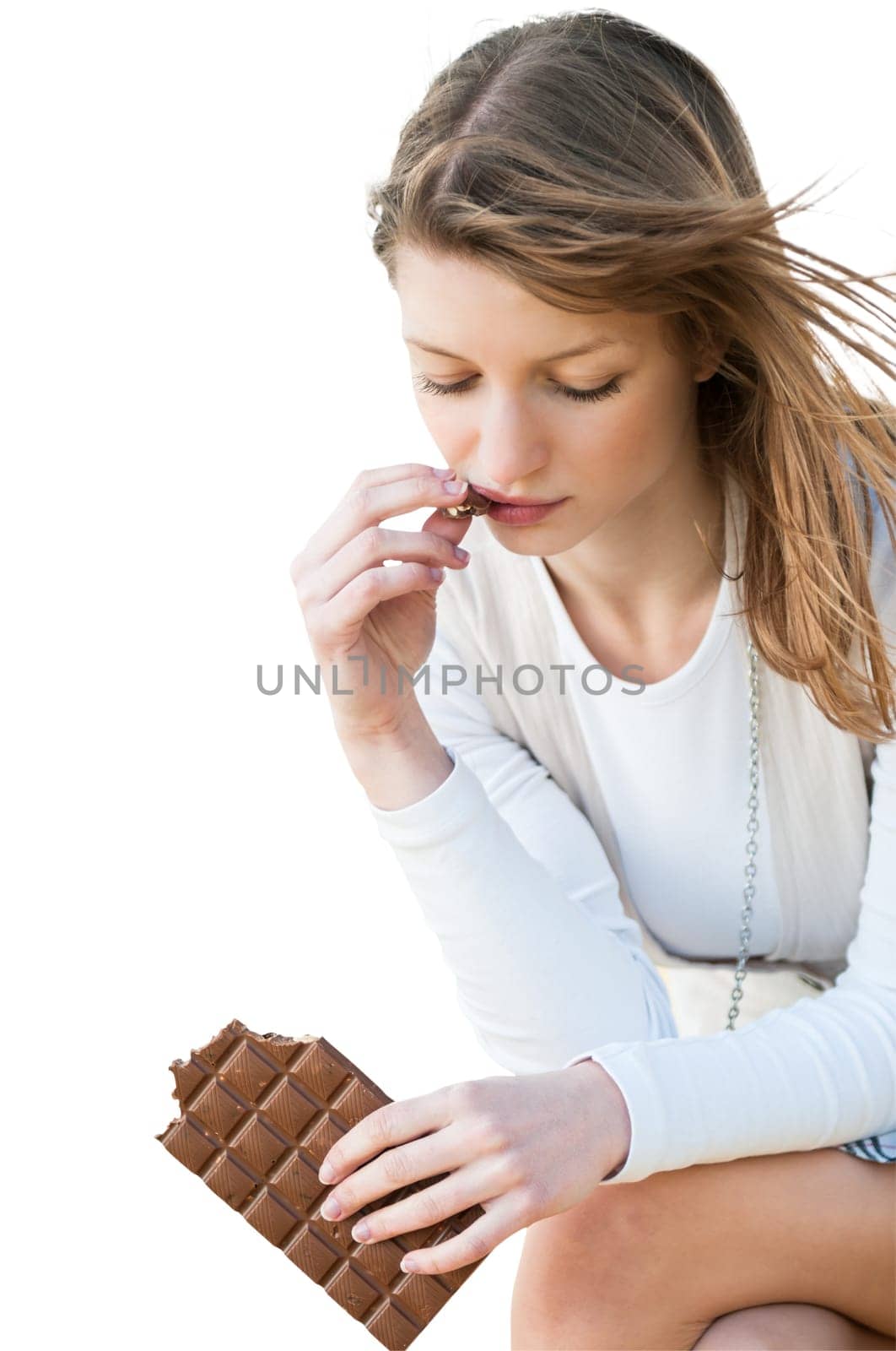 Depression - outdoor portrait of young worried woman eating chocolate