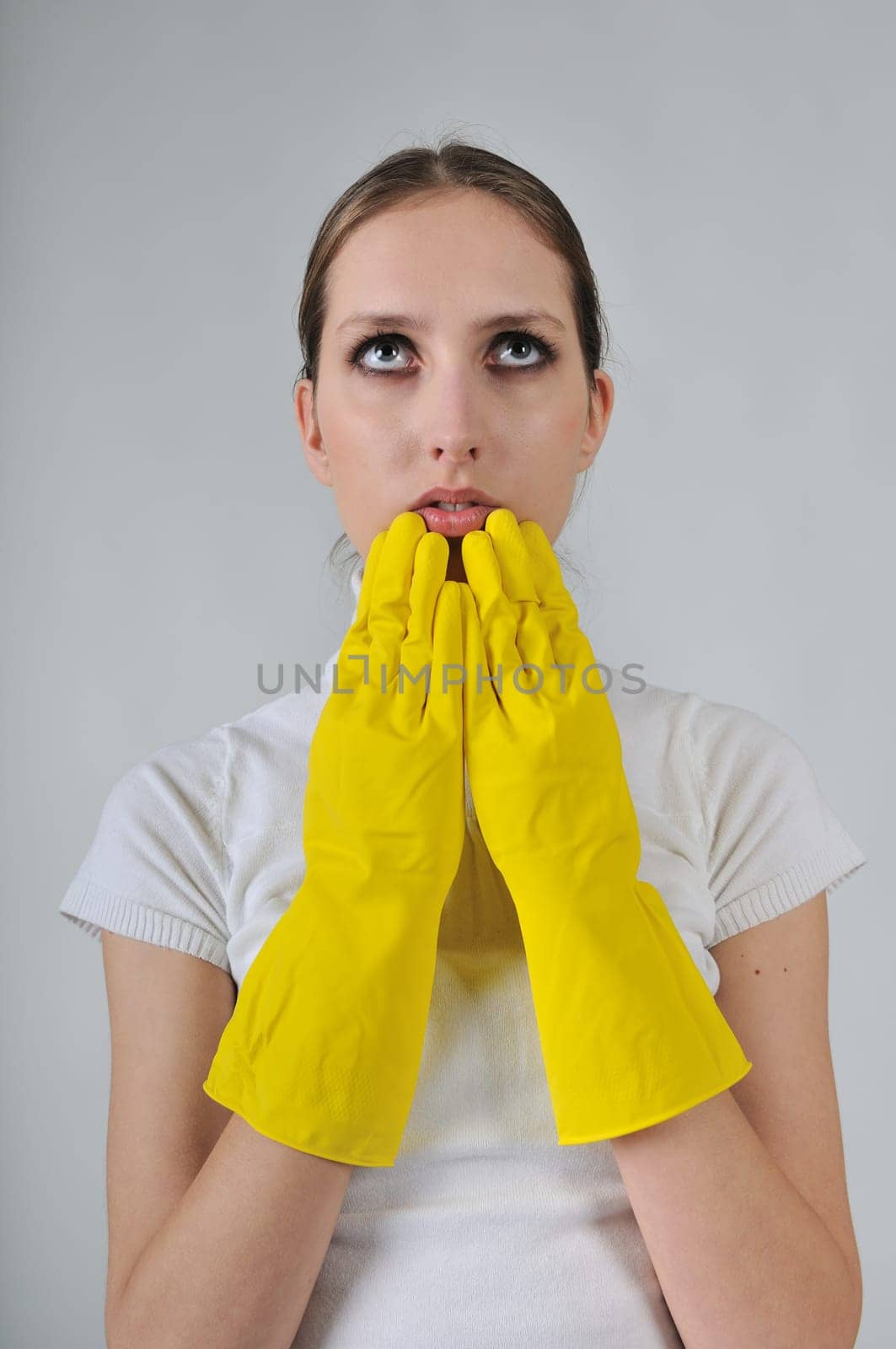 Young woman wearing yellow work gloves with thoughtful expression