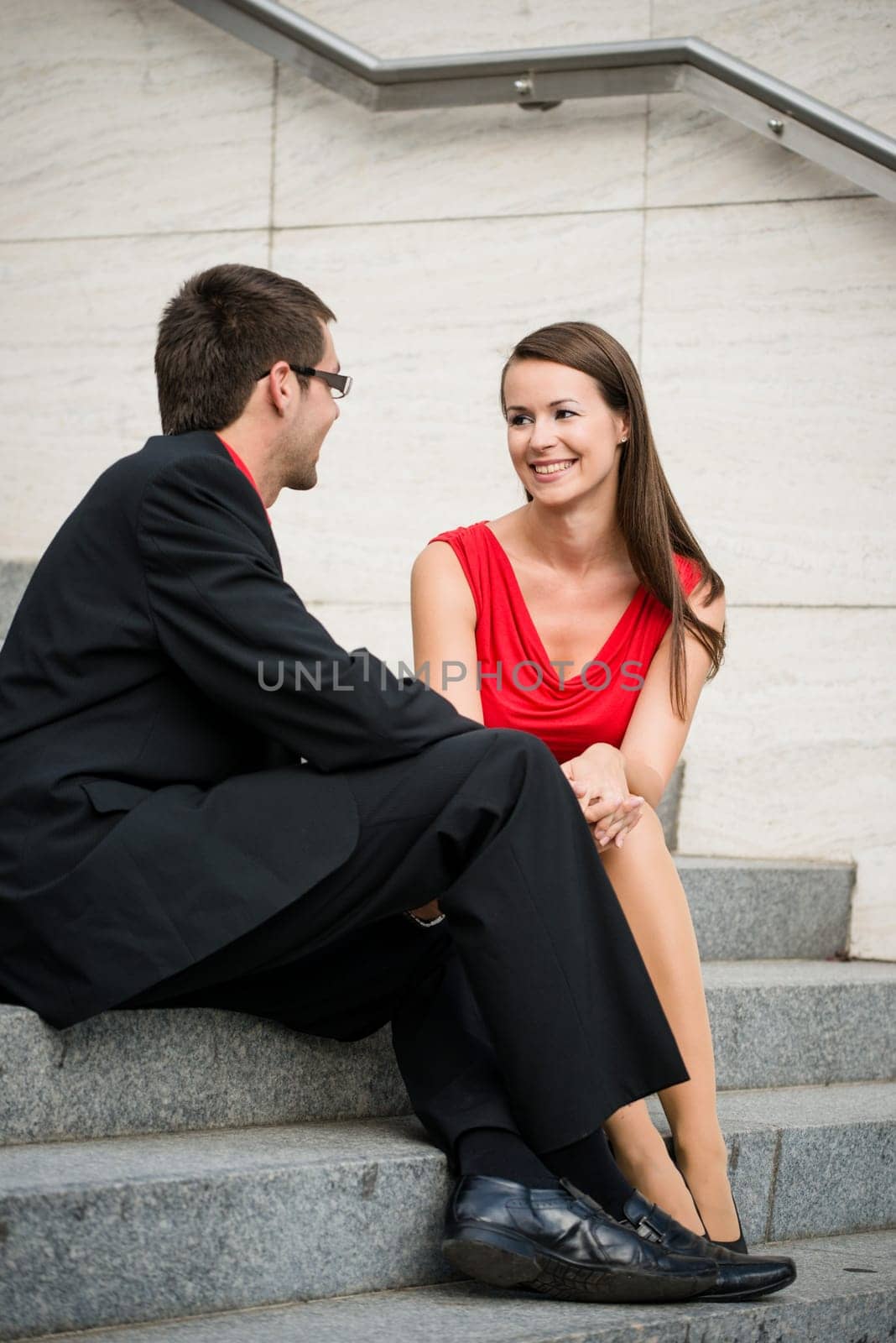 Colleagues - young business people having conversation sitting on stairs