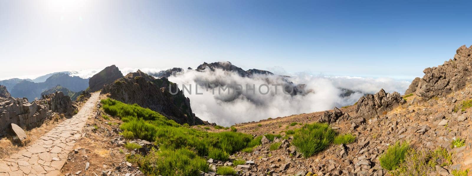 Panoramic view of hiking track high in mountains above the clouds