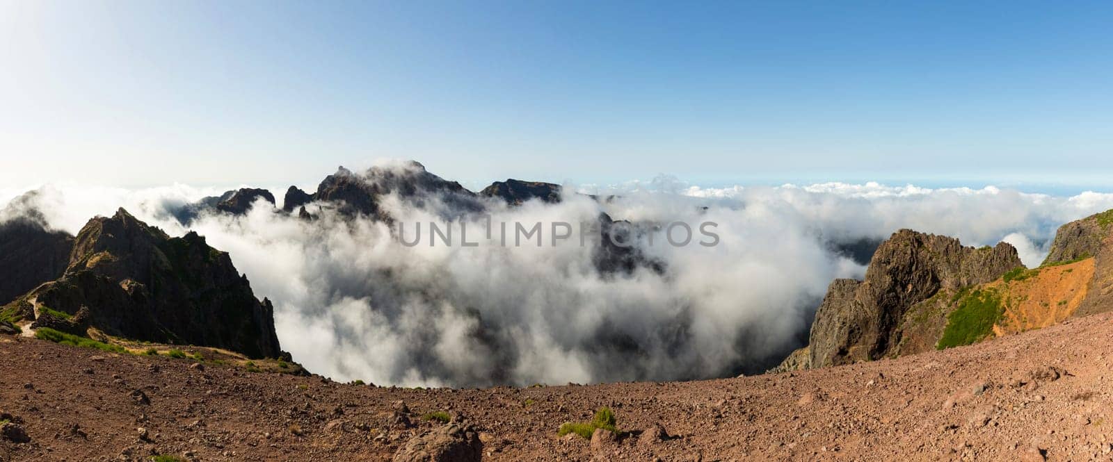 Panoramic view of high mountains above the clouds