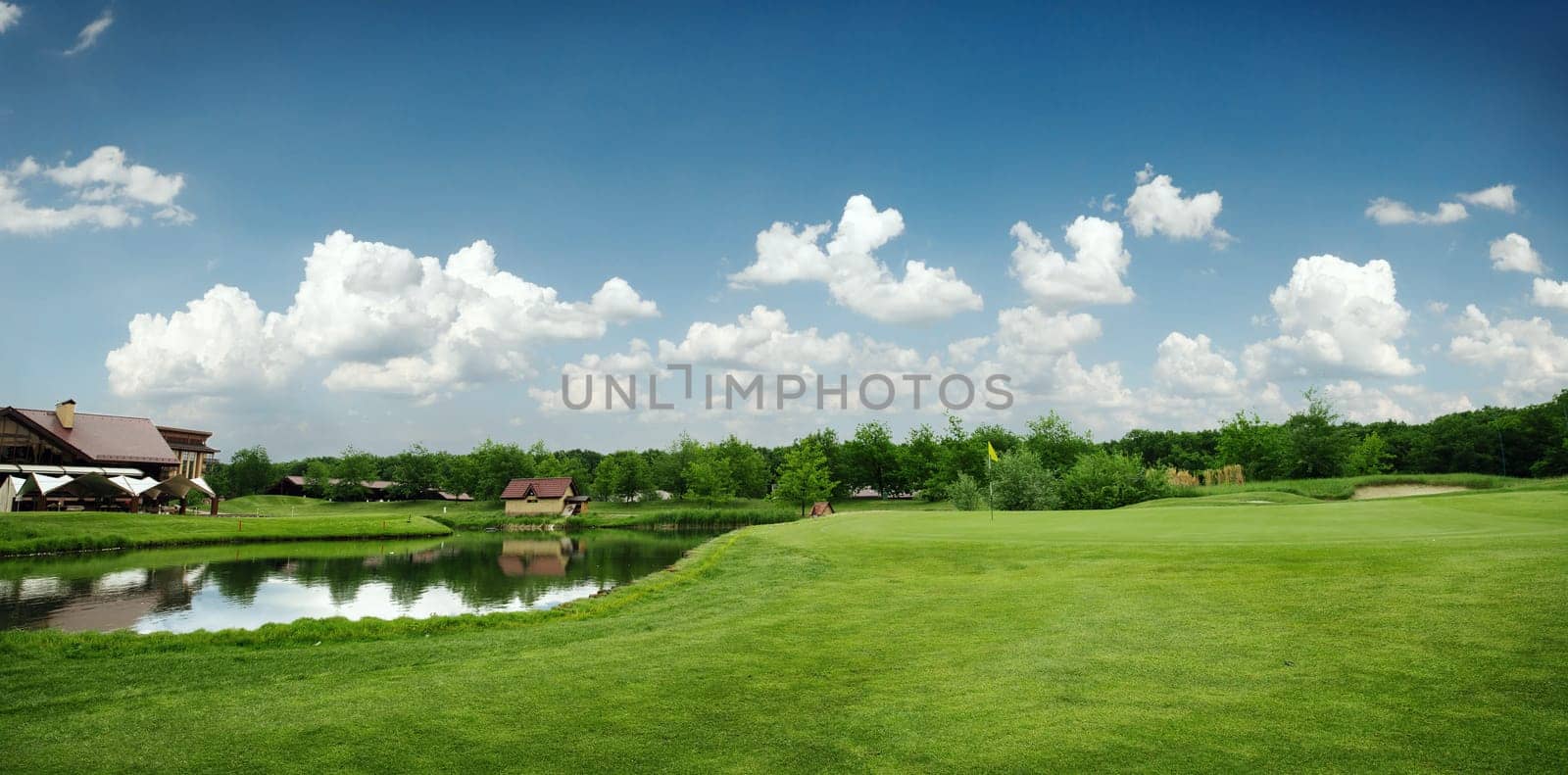 Green field and lake for golfing, golf course, nobody. Meadow in sport club, playground at sunny day, beautiful landscape for summer leisure