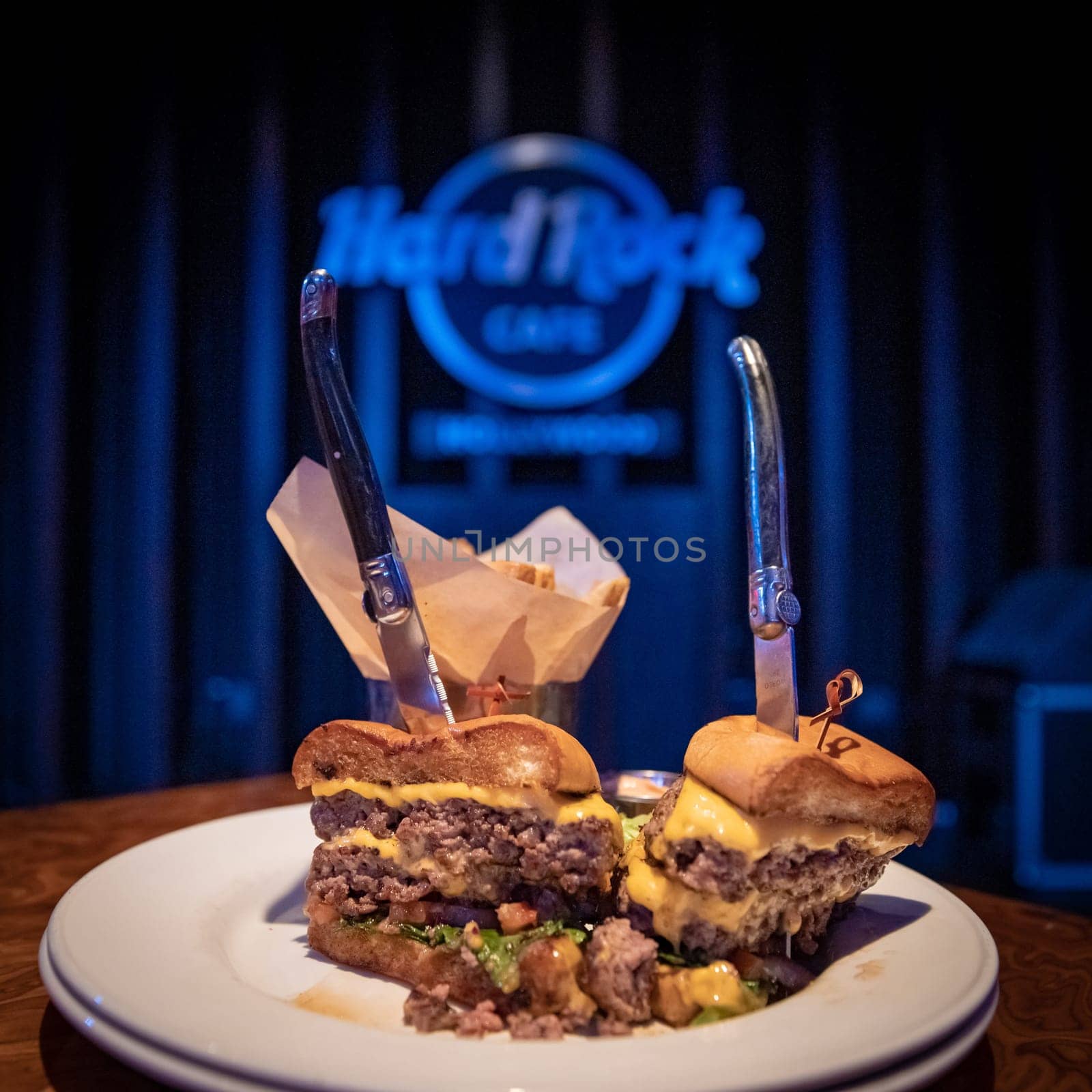 Los Angeles - september 5, 2019. Hamburger on table with Hard Rock Cafe logo in background