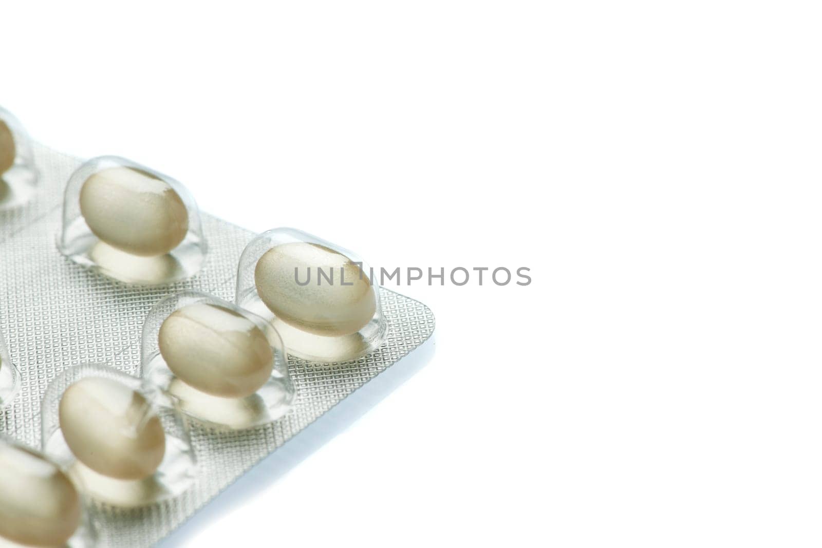 Partial view of a foil packaging for tablet dragees isolated on white background with slight bottom shadow.