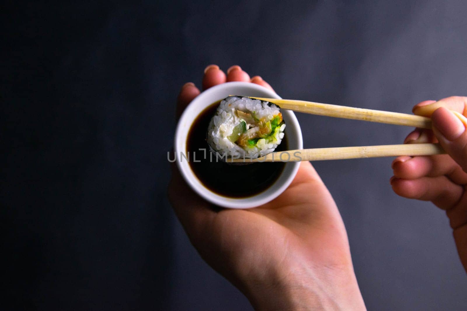 Top view of wooden platter with great set of delicious Nigiri sushi and Tempura rolls with Maki and Uramaki rolls on an rad background. Top views