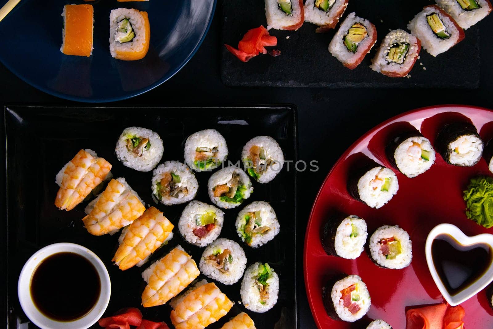 Top view of wooden platter with great set of delicious Nigiri sushi and Tempura rolls with Maki and Uramaki rolls on an orange background. Front views