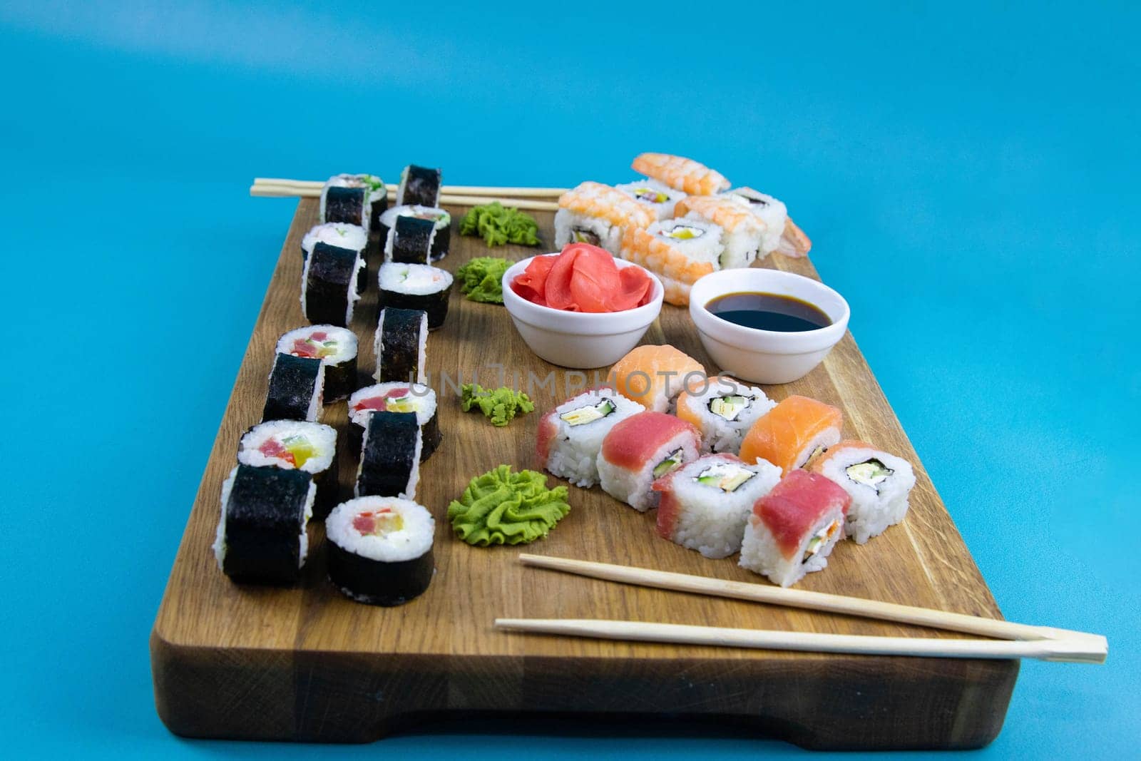 A set of rolls of different kinds with sushi sticks isolated on a black background. Top views